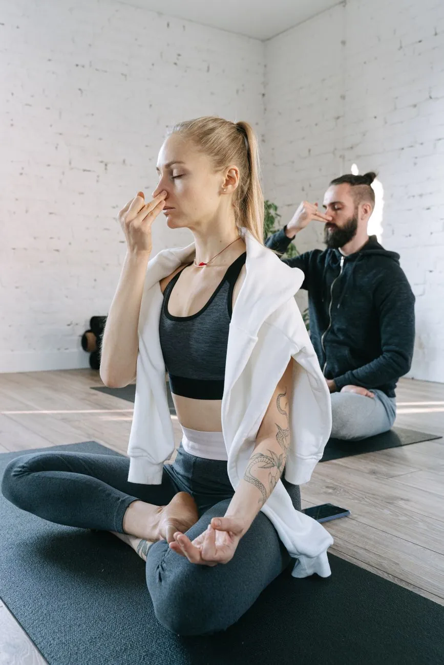 Người tập thở bằng một bên mũi trong lớp yoga sáng